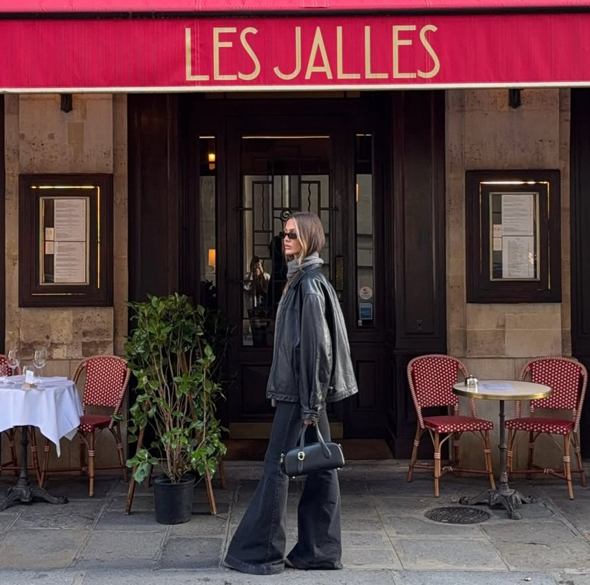 Дівчина на фоні кафе у чорному одязі