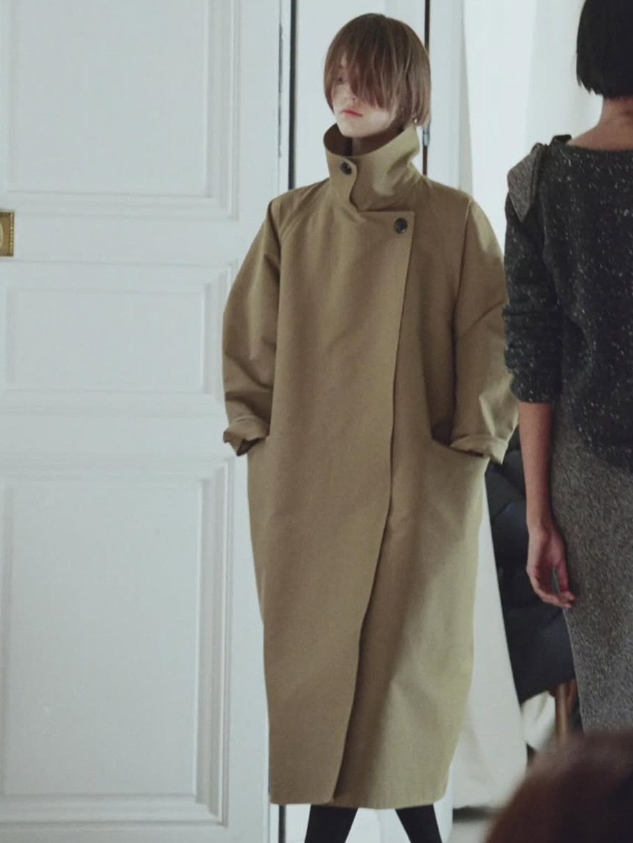 Дівчина у довгому пальті з високим коміром