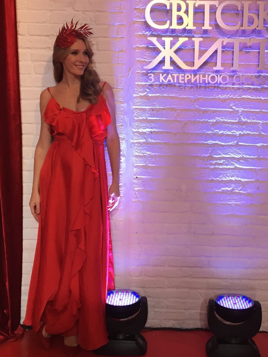 Катерина Осадча у червоній сукні ефектно попозувала коло стіни